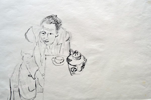 Mann mit Teekanne am Tisch